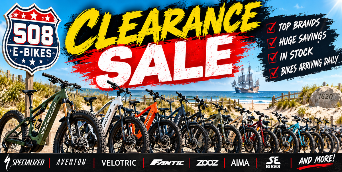 A promotional banner for a 508 E-Bikes clearance sale, featuring a lineup of various electric bicycles in the foreground with a beach and ocean backdrop. Large text reads 'CLEARANCE SALE' in yellow and white, with a blue '508 E-BIKES' logo on the top left.